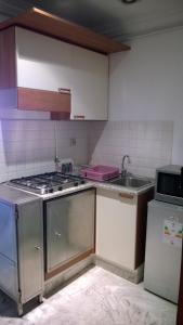 a small kitchen with a stove and a sink at Résidence Ghozlane in Tunis