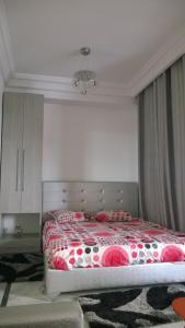 a bedroom with a bed with a red and white blanket at Résidence Ghozlane in Tunis