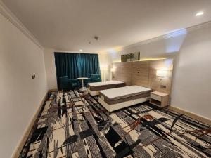 Pokój z sypialnią z łóżkiem i dywanem w obiekcie Helnan Royal w Dubaju