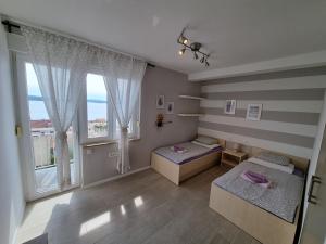 a bedroom with two beds and a large window at Top view in Crikvenica