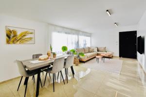 sala de estar con mesa, sillas y sofá en אדמת הארץ - Admat Haaretz en H̱azon