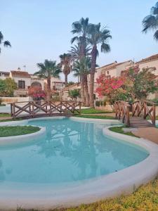 una gran piscina en un patio con palmeras en Apartamento Los Mangos en Roquetas de Mar