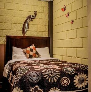 a bedroom with a bed with a flower blanket on it at El Sueño de Quetzalcoatl in San Juan Teotihuacán