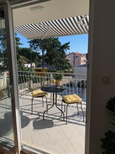 een patio met een tafel en stoelen op een balkon bij Apartment Jukich in Sveti Filip i Jakov