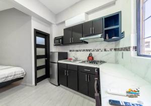 a small kitchen with black cabinets and a bed at San Felipe rental - One block to San Felipe Malecon in San Felipe