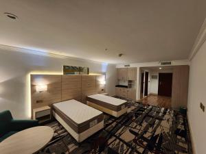 duży pokój z 2 łóżkami i kanapą w obiekcie Helnan Royal w Dubaju