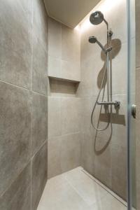 a shower with a glass door in a bathroom at Luxury Residence Kmochova in Prague