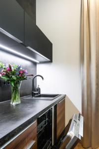 kuchnia ze zlewem i wazonem kwiatów w obiekcie Luxury Residence Kmochova w Pradze