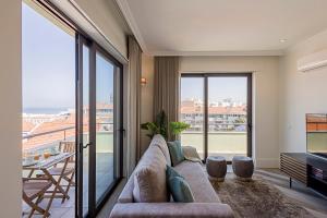 a living room with a couch and a large window at 19 Nineteen Suites - Espinho in Espinho