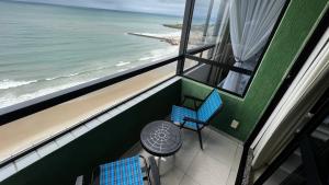 a view of the ocean from a room with a table and chairs at FLAT DE FRENTE PARA O MAR in Natal