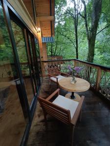 a porch of a cabin with a table and chairs at SAMUR DAĞ EVLERİ in Rize