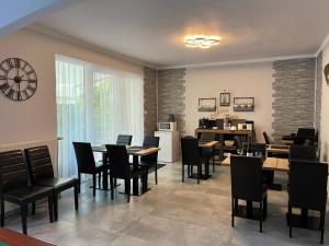 a dining room with tables and chairs and a kitchen at Aventurin House *** in Révfülöp