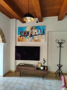 sala de estar con TV de pantalla plana en la pared en Dolci Soggiorni en Loreto