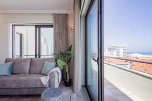 een woonkamer met een bank en een balkon bij 19 Nineteen Suites - Espinho in Espinho