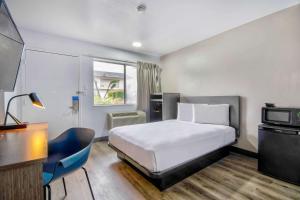 una camera d'albergo con letto, scrivania e TV di Motel 6-Austin, TX - North ad Austin