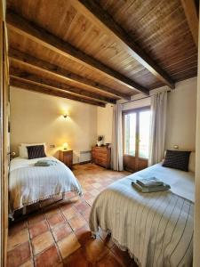 een slaapkamer met twee bedden en een groot raam bij El Xalet de la Padrille in Enveitg