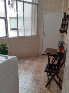 Cette chambre dispose d'une porte blanche et d'une table avec des plantes. dans l'établissement Apt. em Ipanema entre a praia e a Lagoa, à Rio de Janeiro