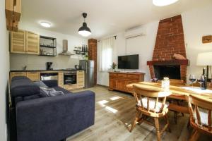 ein Wohnzimmer mit einem Sofa und einem Tisch sowie eine Küche in der Unterkunft Lijana in Bratulići (Haus für 4 Personen) in Barban