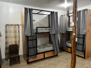 a room with three bunk beds in a room at The Backyard Inn in Moalboal