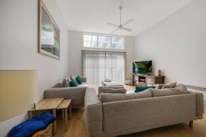 un soggiorno con un divano e una TV di THE BAY - luxury accommodation by the sea a Warrnambool
