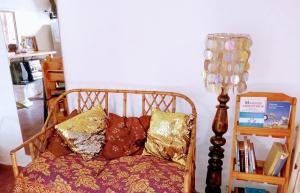 silla con almohadas y lámpara en la habitación en Casargentina Apart Depto entero Baño privado 15min Ezeiza en Monte Grande