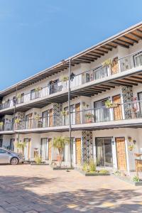 un immeuble d'appartements avec une voiture garée devant lui dans l'établissement Hotel Posada El Rey Sol, à Ensenada