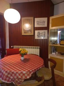 una mesa de comedor con un jarrón de flores. en Lake Maggiore 2 Minutes Apartment en Dormelletto