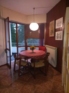 una sala da pranzo con tavolo, sedie e una finestra di Lake Maggiore 2 Minutes Apartment a Dormelletto