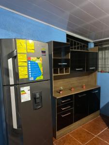 a kitchen with a stainless steel refrigerator and cabinets at La Casa de Detours Costa Rica in Fortuna