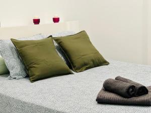 ein Bett mit vier Kissen und einem Handtuch darauf in der Unterkunft BEST FLAT NEAR REAL MADRID STADIUM in Madrid