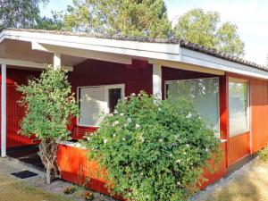 Bøtø Byにある6 person holiday home in V ggerl seの前に木が2本ある赤い家