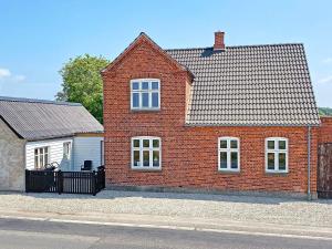 una casa de ladrillo rojo con garaje blanco en Holiday home Tranekær IX en Tranekær