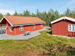 a red building with a bench in front of it at 6 person holiday home in Fur-By Traum in Fur