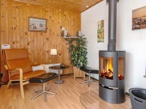 a living room with a fireplace and chairs at 4 person holiday home in Harbo re in Harboør