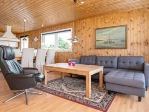 a living room with a couch and a table at 4 person holiday home in Harbo re in Harboør