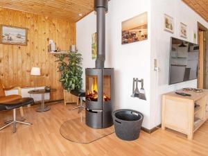 a living room with a fireplace in the corner of a room at 4 person holiday home in Harbo re in Harboør