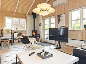 sala de estar con TV grande y chimenea en Holiday home Otterup XXIV en Otterup