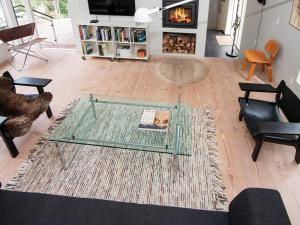 a living room with a glass table and a fireplace at 8 person holiday home in Ebeltoft in Ebeltoft