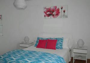 - une chambre avec un lit doté d'oreillers rouges et bleus dans l'établissement Casita del Mar a pie de playa, à Tarifa