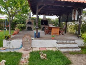 a gazebo with a fireplace and ducks in the grass at ΕΝΟΙΚΙΑΖΟΜΕΝΟ ΔΩΜΑΤΙΟ ΜΕ ΘΕΑ ΣΤΗΝ ΕΞΟΧΗ in Rodhókipos