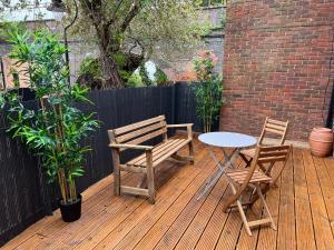 un patio con mesa, 2 sillas y una mesa en 3 Bedroom Town House in Central Muswell Hill London en Londres