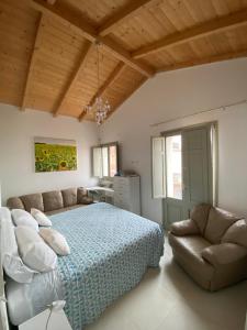 - une chambre avec un lit et un canapé dans l'établissement Casa Opera, à SantʼAntìoco