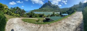 an aerial view of a dirt road with a house and a mountain at Bora Temahana in Bora Bora