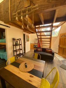 sala de estar con mesa de madera y sillas amarillas en Lemudomos, en Pichilemu