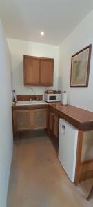 a kitchen with a wooden counter and a white refrigerator at Amanda's Place Yellow Studio - Pool and Tropical garden in Caye Caulker