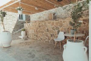 a patio with a table and chairs and a stone wall at AkoumiaStudio in Akoumia