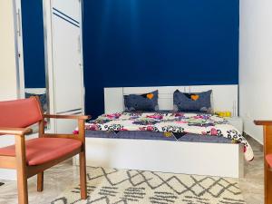 um quarto com uma cama com uma parede azul em RESIDENCE EL HADJI em Dakar