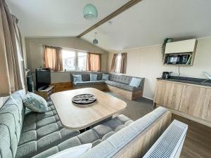 a living room with a couch and a table at Modern 6 Berth Caravan With Wifi At St Osyth Beach In Essex Ref 28051fv in Clacton-on-Sea