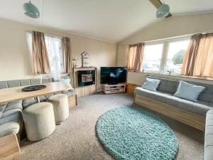 een woonkamer met een bank en een tafel bij Modern 6 Berth Caravan With Wifi At St Osyth Beach In Essex Ref 28051fv in Clacton-on-Sea