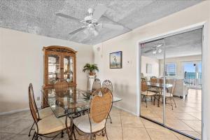 a dining room with a ceiling fan and a table and chairs at Holiday Surf and Racquet Unit 520 in Destin